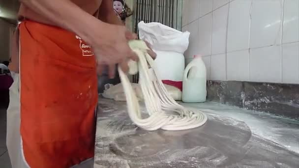 PHNOM PENH CAMBODIA - CIRCA MAY 2014: Young Asian man kneads and stretches Chinese Noodles (#2) — Stock Video