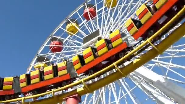 Een achtbaan snelheden door op een overhead track; renners kunnen worden gehoord screamin — Stockvideo