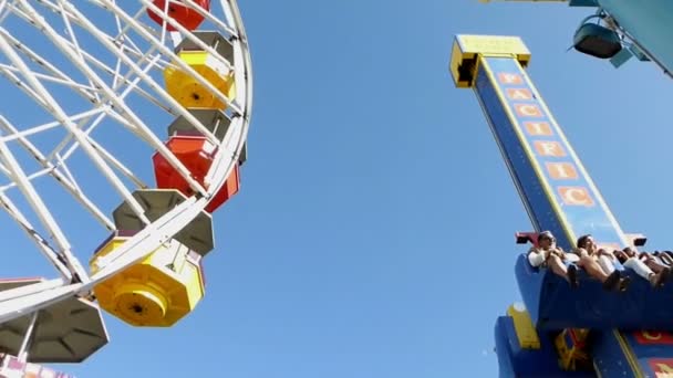 A spidery wonder wheel rotates wildly with riders whirling around and screami — Stock Video