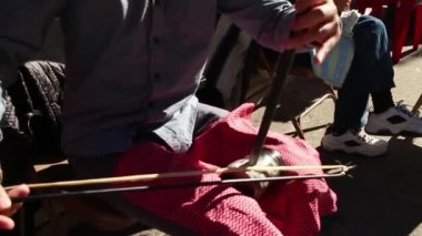 60 fps yerli yavaş hareket Asyalı müzisyen yaylı enstrüman çalış