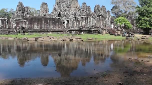Ancient Temple (Angkor) - WS tilt up to Bayon from pool — Stock Video