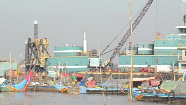 Télé vue à travers de petits bateaux de pêche avec péniche industrielle sur le Mékong — Video