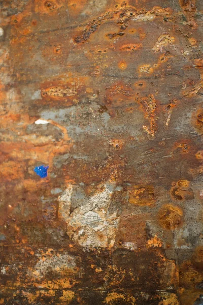 Vista vertical de la pared metálica erosionada oxidada con trozos de papel — Foto de Stock