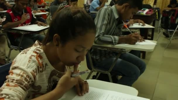 SIEM REAP, CAMBODIA: 12 de setembro de 2015: Estabilizado ampla foto de uma sala cheia de estudantes universitários cambojanos tomando um — Vídeo de Stock