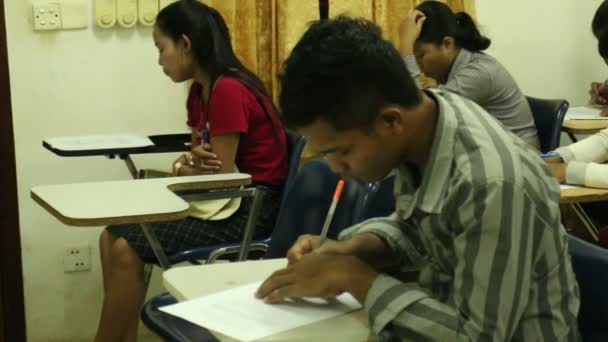 SIEM REAP, CAMBODIA: SEPTEMBRO 12, 2015: Estudantes asiáticos fazendo um exame de médio prazo com câmera se movendo através de linhas para revelar — Vídeo de Stock