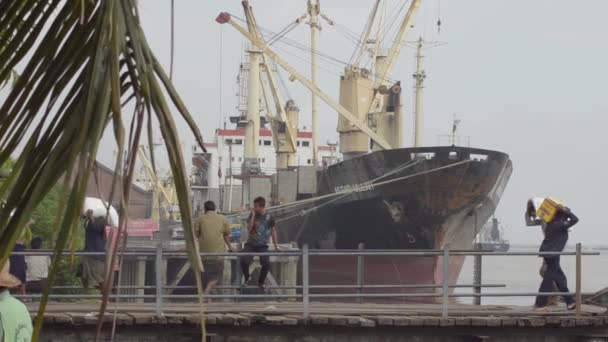 26 DE ABRIL DE 2014 - RANGOON, BURMA: Los porteadores transportan mercancías en la pasarela con el barco visible — Vídeos de Stock