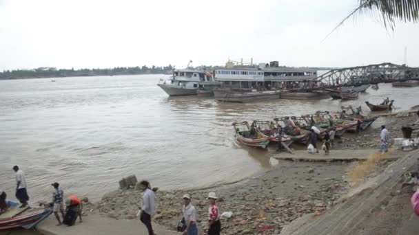 26 Nisan 2014 - Rangoon, Burma: Pan kişi kova sıvı fırlatır gibi nehir kenarında bir limanda bekleyen tekneler arasında — Stok video