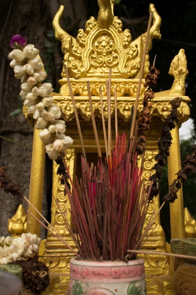 Extreme Nahaufnahme eines Gold Spirituosenhauses in Südostasien, mit Weihrauch und Blumen in der Mitte (vertikal) — Stockfoto