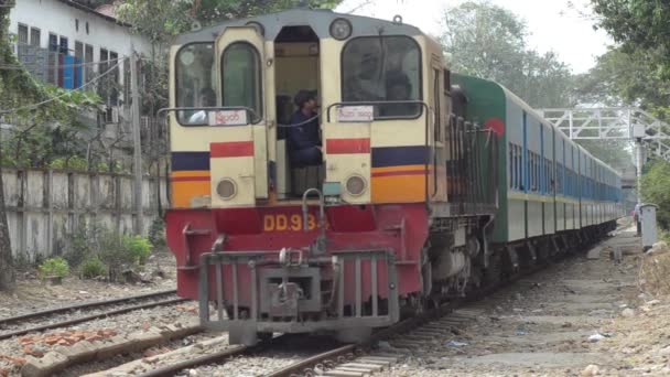 YANGON, MYANMAR - 25 AVRIL 2014 : Train à rayures jaunes et rouges approchant et passant — Video