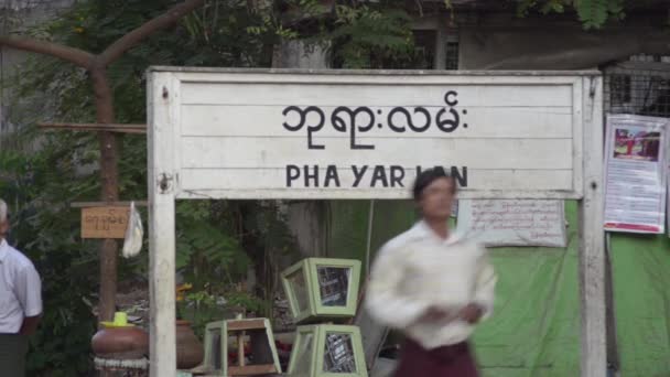 Янгон, Мьянма - 25 апреля 2014 года: Подпишитесь на бирманском и английском языках на железнодорожной станции Платформа — стоковое видео