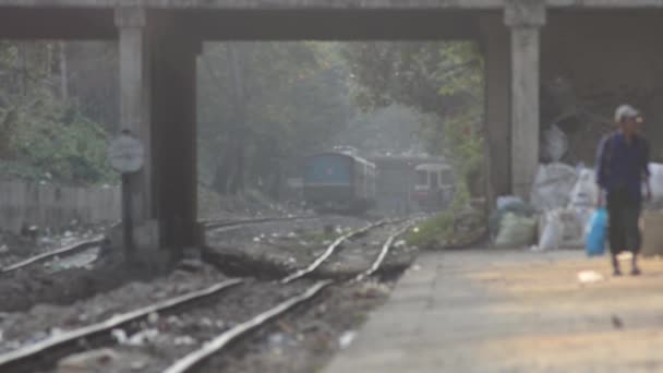 YANGON, MYANMAR - 25 DE ABRIL DE 2014: Vista en ángulo bajo de trenes distantes rodando a cámara en vías distantes — Vídeos de Stock