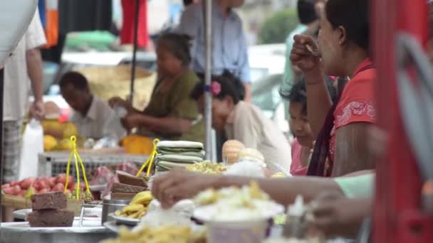 YANGON, MYANMAR - 25 APRILIE 2014: Vedere la nivel de masă a rândul vânzătorilor cu alimente pe o piață în aer liber — Videoclip de stoc