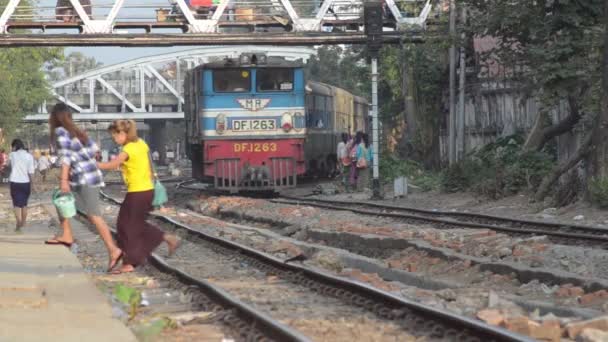 LOCOMOTIVA DEL TREN: Se acerca el tren rojo y azul entre los peatones — Vídeos de Stock
