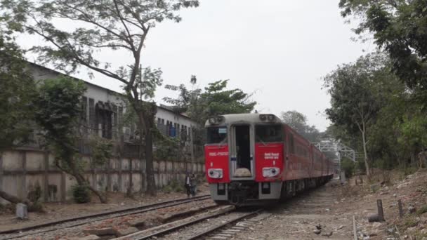 TREN - LOCOMOTIVE: El tren rojo pasa con el niño colgando del costado — Vídeo de stock