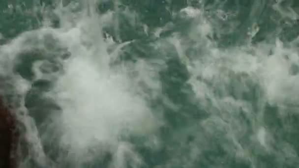 Water from an overhead waterfall hitting a pool and churning it energetically — Stock Video