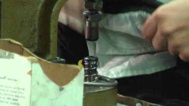 Phnom Penh, Kamboçya - 12 Eylül 2012: Asya konfeksiyon Sanayi Fabrikası: Cu damga düğmeleri, vınlamak dışarı