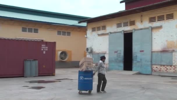 PHNOM PENH, CAMBODIA-SETTEMBRE 14, 2012: Industria dell'abbigliamento asiatica Fabbrica: Pan / Zoom Worker Rolls Barrel — Video Stock