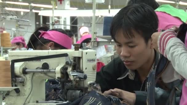 PHNOM PENH, CAMBODIA-SEPTEMBER 14, 2012: Textile Cloment Factory Workers: MCU male worker sewing jeans machine — стоковое видео