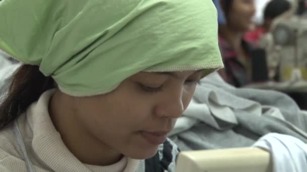 PHNOM PENH, CAMBODIA-SEPTEMBER 13, 2012: Textile Cloment Factory: Worker prepares and sews fabric sections — стоковое видео