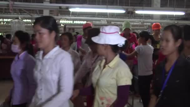 PHNOM PENH, CAMBODIA-SEPTIEMBRE 13, 2012: Textile Garment Factory Workers: sideview wide shot many workers outiting factory — Vídeos de Stock