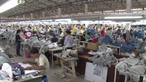 PHNOM PENH, CAMBODIA-SEPTEMBER 13, 2012: Textile Garment Factory: Wide shot pan across garment factory floor and hold — стоковое видео