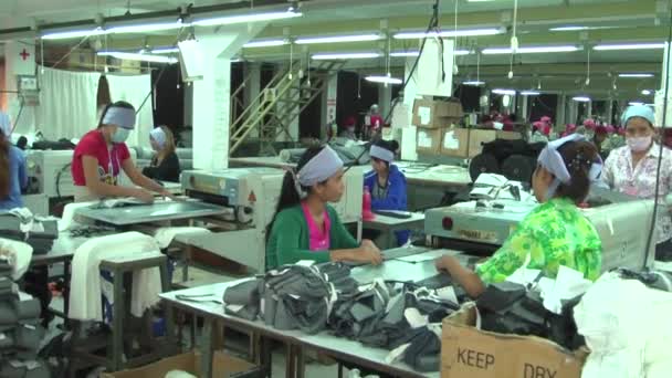 Phnom Penh, Cambodja-13 september 2012: Aziatische kledingindustrie fabriek: Slow pan rond textiel rollende ruimte — Stockvideo