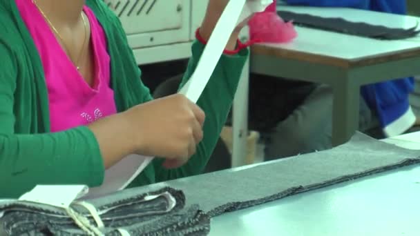 PHNOM PENH, CAMBODIA-SEPTEMBRO 13, 2012: Fábrica asiática da indústria do vestuário: Trabalhadora do sexo feminino MCU, incline-se para as mãos da CU no rolo — Vídeo de Stock