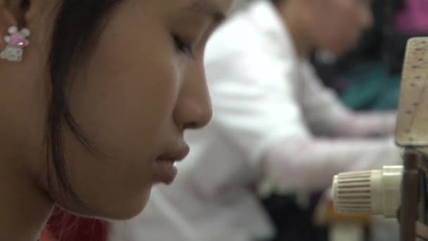 プノンペン、カンボジア-2012年9月13日:繊維衣料工場労働者:縫製中の労働者の顔のCuプロファイル — ストック動画