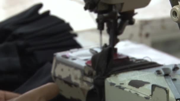 金边，柬埔寨-2012年9月12日：纺织服装厂工人：将深色织物片件放入缝纫机 — 图库视频影像