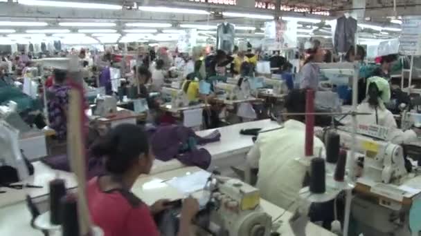 PHNOM PENH, CAMBODIA-SEPTEMBER 12, 2012: Textile Cloment Factory Workers: Move into table of workers folding fabric — стоковое видео