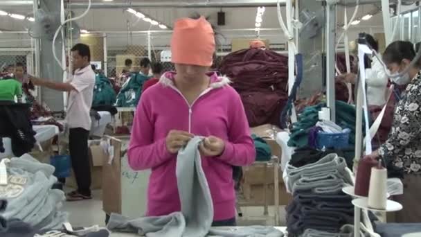 Textiel kledingfabriek: staande kleding arbeider Preps voltooide kledingstuk — Stockvideo