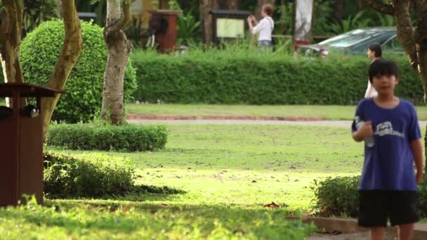 SIEM REAP, CAMBODIA - DECEMBER 10, 2015: Children, adults, and jogger in park in Asia — Stock Video