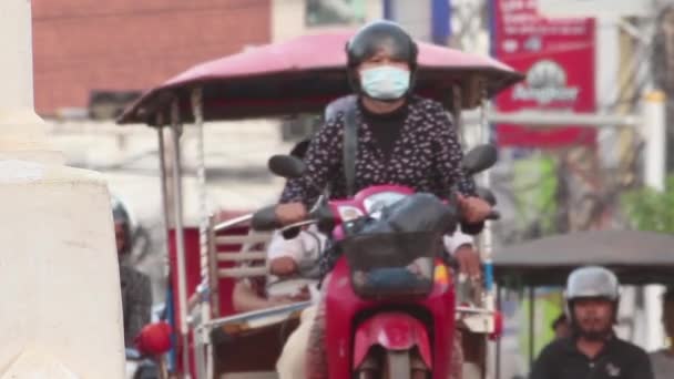 Siem Reap, Καμπότζη - 10 Δεκεμβρίου 2015: Ασιατικές απασχολημένος κυκλοφορίας, σκούτερ πρόγραμμα οδήγησης ελέγχει το τηλέφωνό του στην πολυσύχναστη κυκλοφορίας στην Ασία — Αρχείο Βίντεο