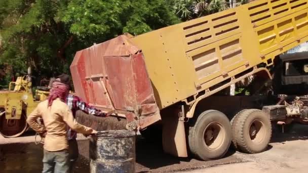 SIEM REAP, CAMBODIA - 23 DE JULIO DE 2015: Gran tirada de camión volquete vertiendo grava mientras rueda en reversa — Vídeo de stock