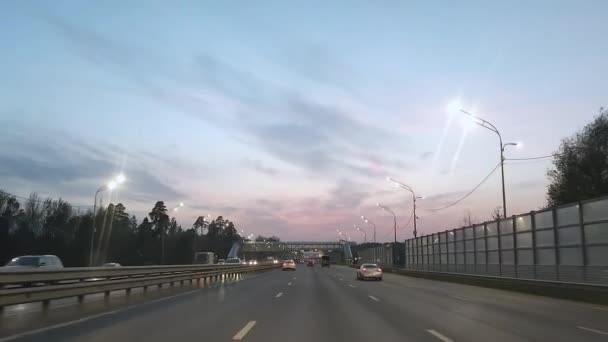 13.10.2020 Moskwa. Rosja Widok przez przednią szybę samochodu na drodze w godzinach wieczornych przy włączonych światłach ulicznych. — Wideo stockowe