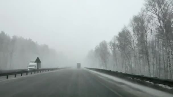 Kilátás a szélvédőn keresztül egy autó az autobahn télen nehéz hóban. — Stock videók