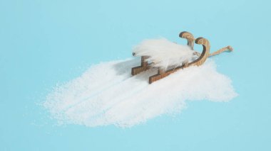 Mavi arka planda kar ve beyaz kızakla yaratıcı bir fikir. Asgari Yeni Yıl veya Noel konsepti.