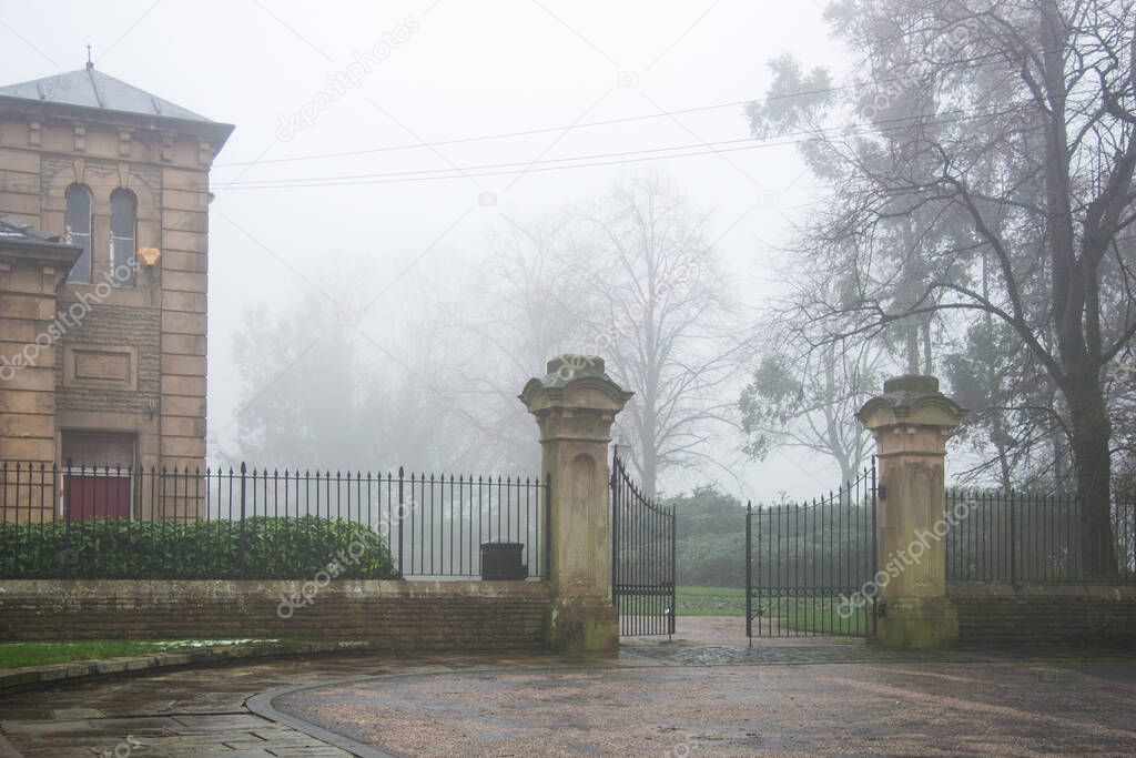 Iron gates to English park in the fog and mist, gloomy and broody mood, contemplate and melancholy, goth feel.