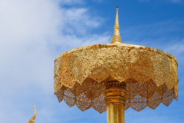 Mavi gökyüzünün altında altın katmanlı şemsiye