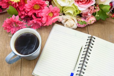 Bir boş beyaz defter, kalem ve de üzerinde sıcak kahve açmak