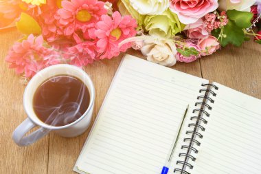 Bir boş beyaz defter, kalem ve de üzerinde sıcak kahve açmak