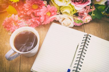 Bir boş beyaz defter, kalem ve de üzerinde sıcak kahve açmak