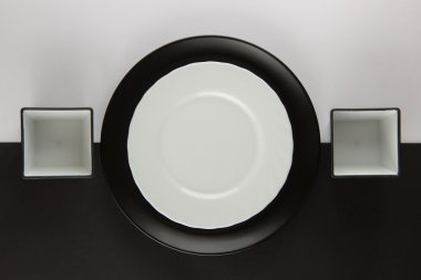 Düz tabak ve bardak siyah ve beyaz arka plan üzerinde bir dizi