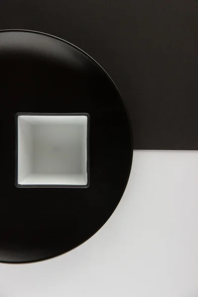 Um número de placas planas e copos em fundo preto e branco — Fotografia de Stock