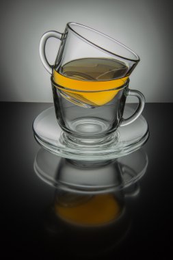 İki cam fincan çay ve siyah ve beyaz bir adam üzerinde uçan daire ile