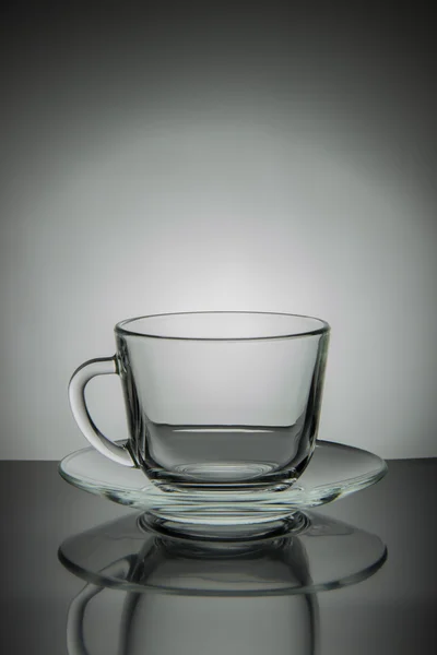 Tazza vuota di tè e piattino in vetro su uno sfondo bianco e nero — Foto Stock