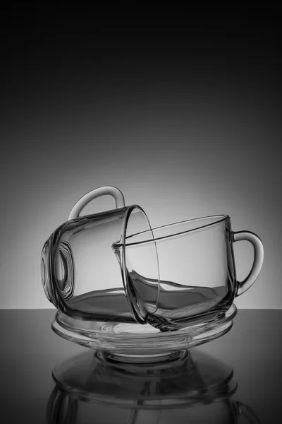 Duas xícara de vidro para chá e um pires vazio em um fundo preto — Fotografia de Stock