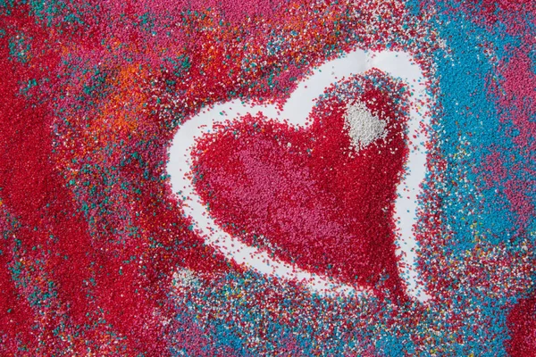 Güzel kalp arka plan üzerinde renkli kum deniz kabukları yapılan — Stok fotoğraf