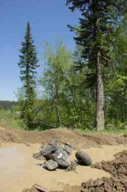 Bir su birikintisi bir orman yolu üzerinde büyük kirli Atv sıkışmış