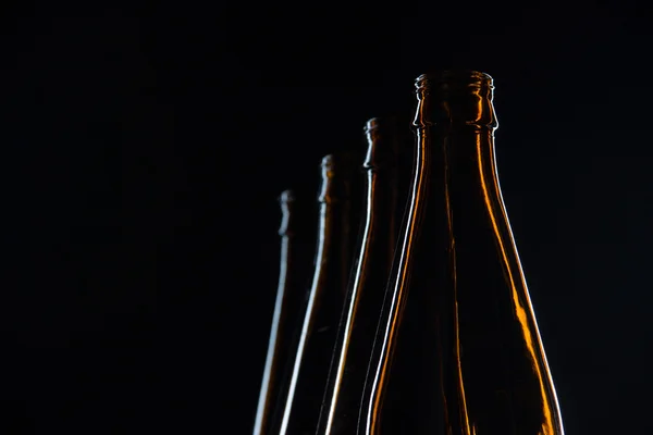 Garrafas de vidro de silhuetas de cerveja em um fundo preto — Fotografia de Stock